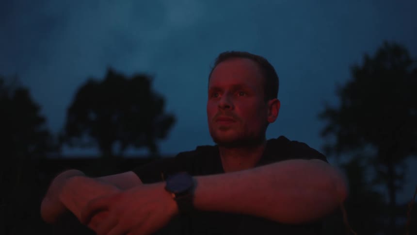 Man sitting in front of a campfire at night