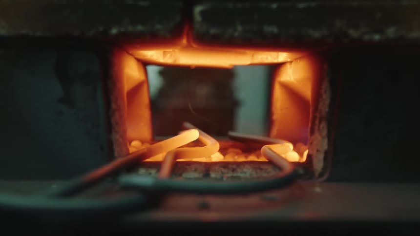 Closeup of metallic irons being super heated for forging