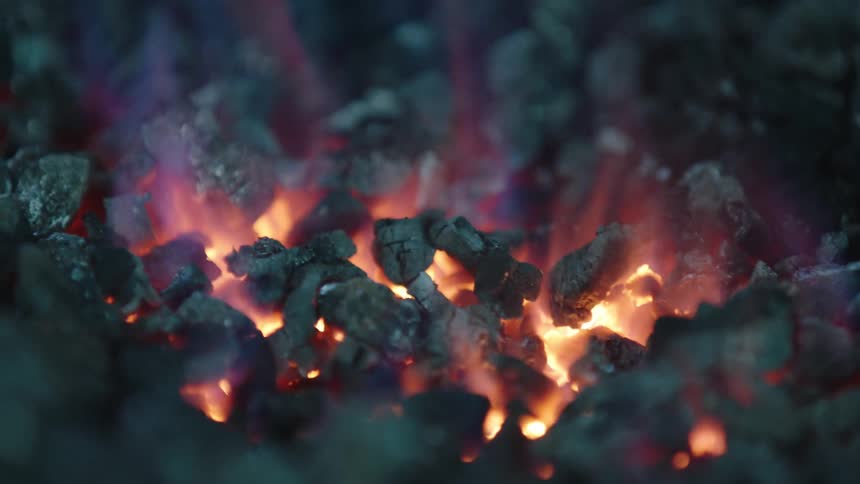 Closeup of glowing embers catching fire
