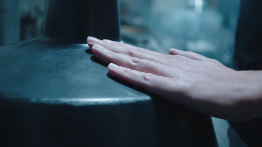 A human hand passing the palm across the surface of a smooth object