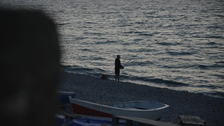 A clip of a person fishing by the shore