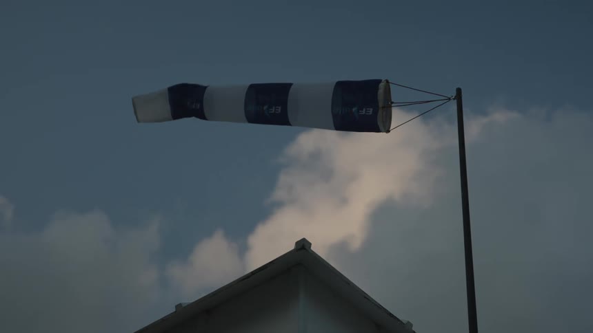 A wind direction flag is moving as the wind passes through it