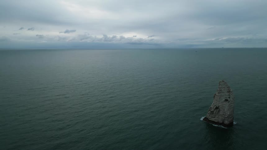 Aerial view of a rock cliff in the middle of the ocean