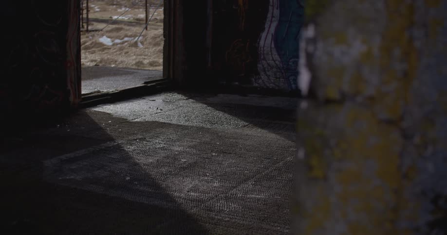 The light shines in a dark room from the doorway