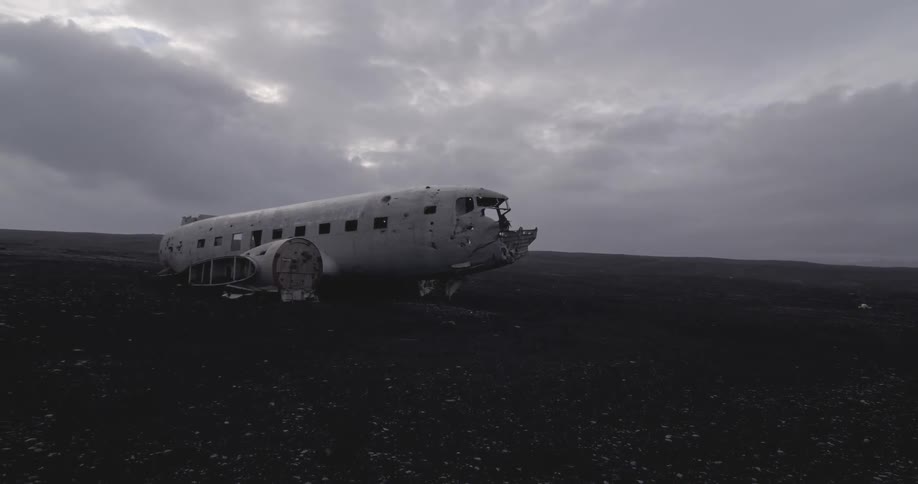 A downed plane is on a field on a cloudy day