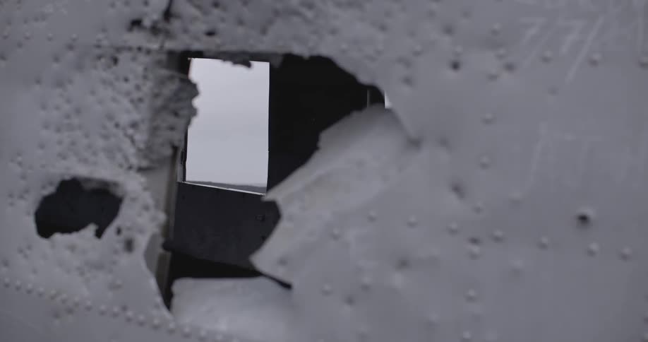 Hole in the wall reveals  light on the other side