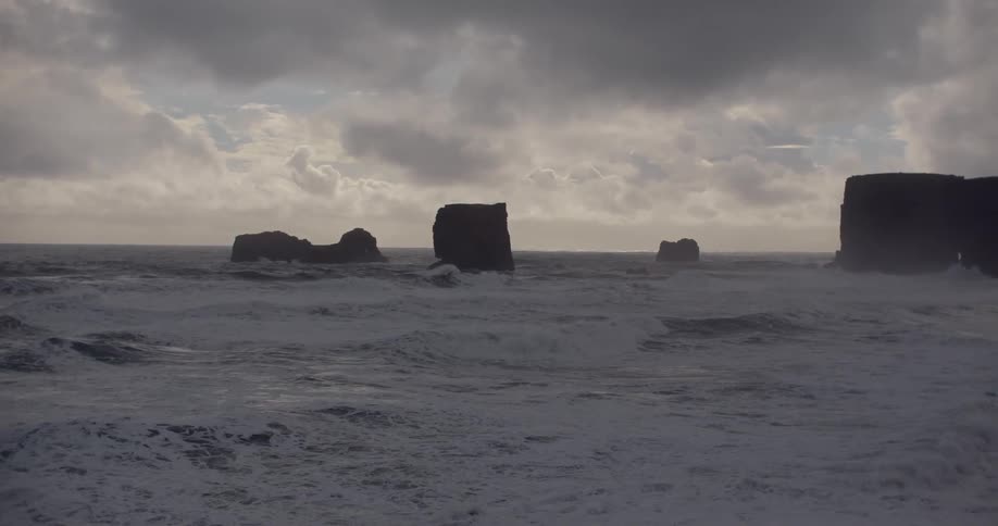 Water flows on the shoreline as rock walls stand tall above the water