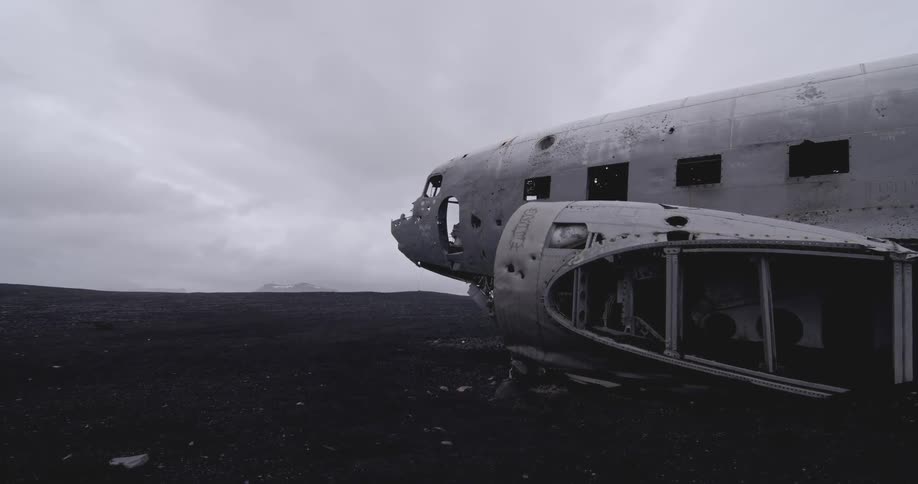 Airplane skeleton sitting in a barren land on a very cloudy day