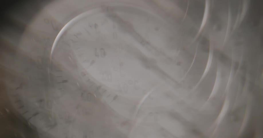 Hand rotates around analog temperature display as person moves nearby