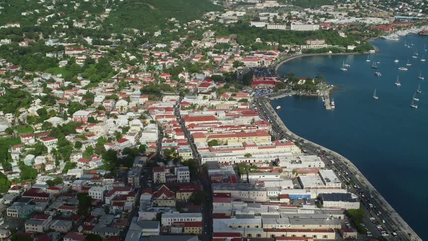 An aerial view of a coastal city with densely packed buildings next to the shoreline