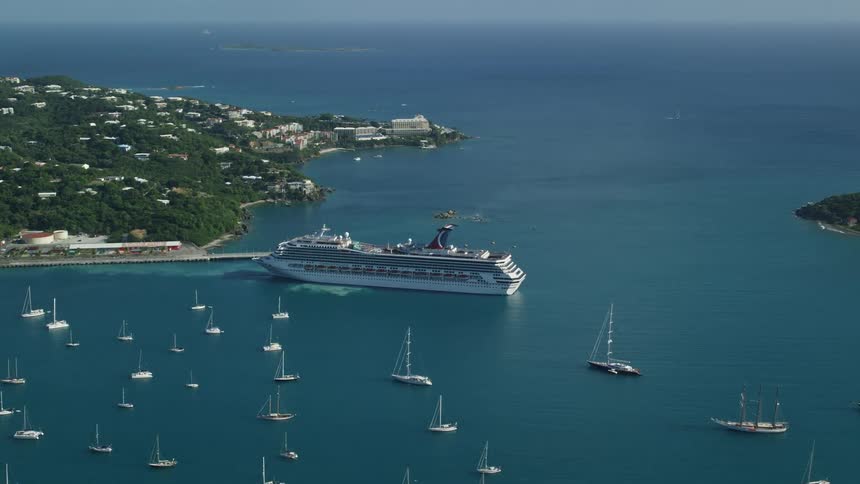 A cruise ship sits along the coast of a bay