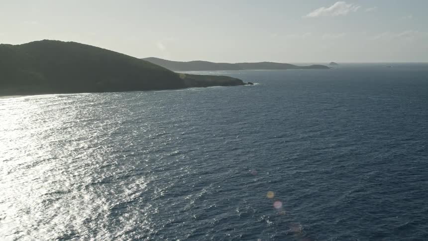 Aerial view of the coast and the blue sea with the morning sun