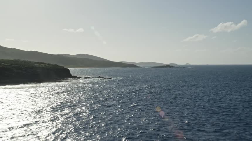 Aerial view over ocean coastline on partly cloudy day