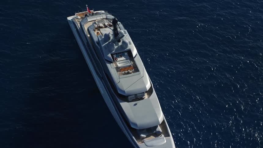 White yacht floats in the middle of a deep blue sea on a sunny day