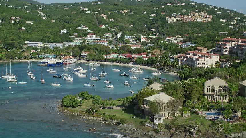 Aerial panorama overlooking the turquoise sea with yachts around and houses hotels and mansions on the coast