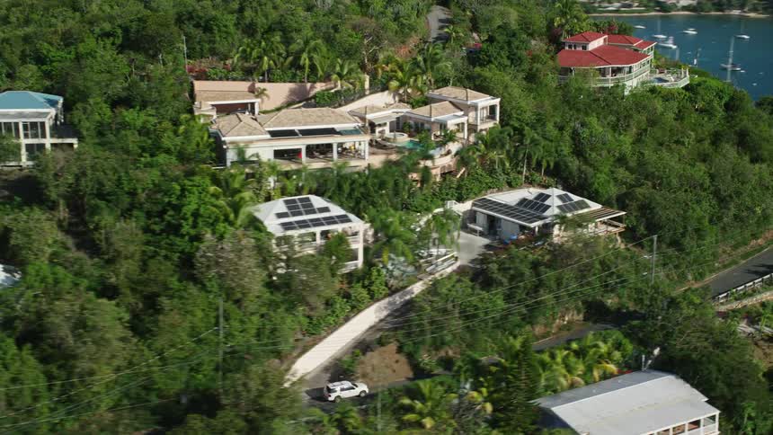 Homes dot the sides of a mountainous coastal area