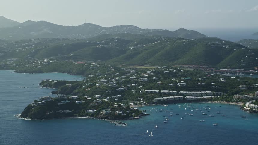 Aerial of a small coastal town with mountains during the day