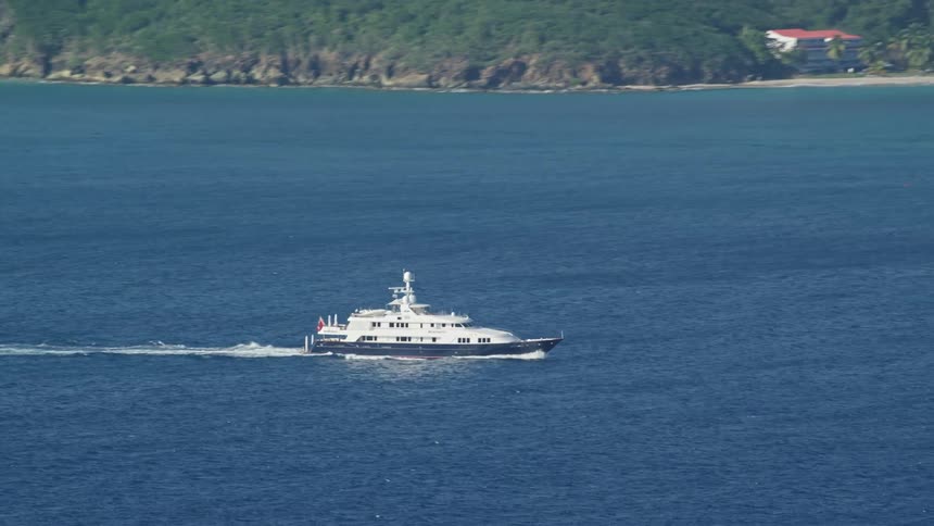 A yacht travelling parallel to the coast