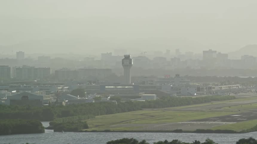 A tower rises above a concentration of buildings near a city