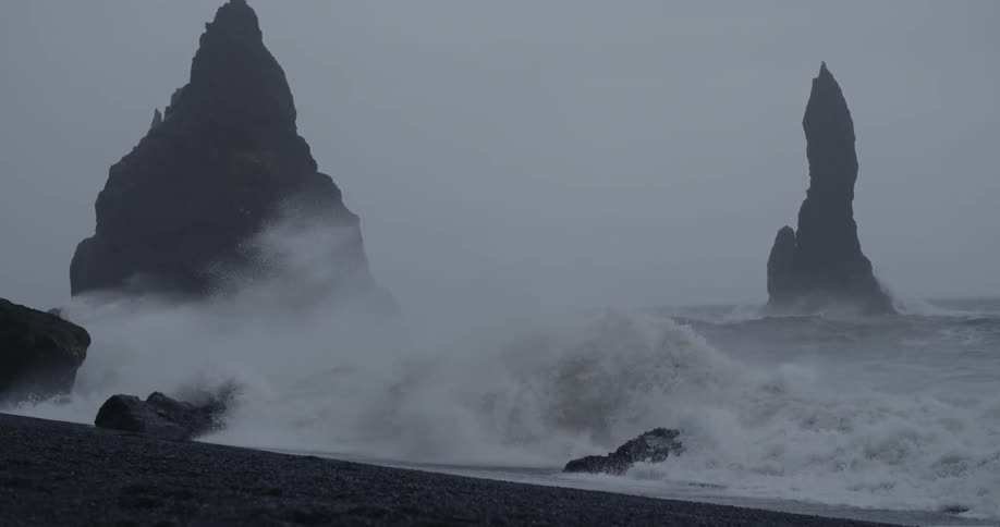 Large waves crash up on rocky beach
