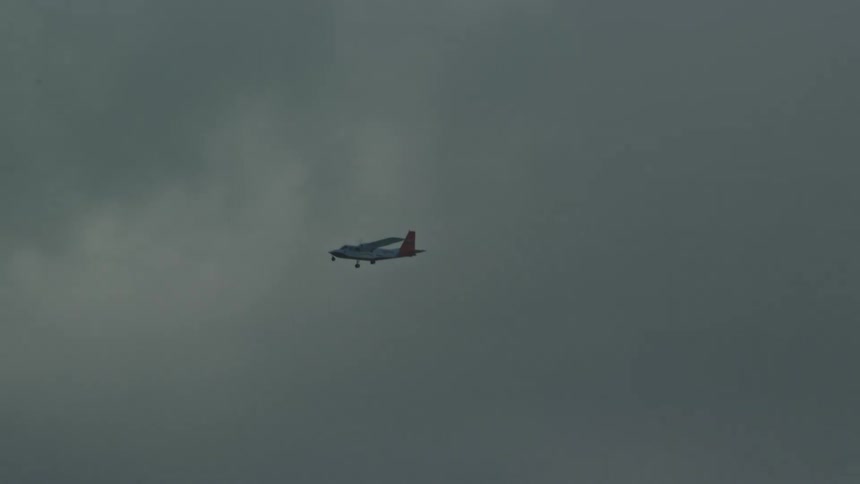 A small airplane flying overhead on a cloudy day
