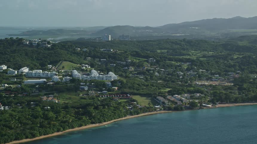 A coastal town spread in areas of dense vegetation