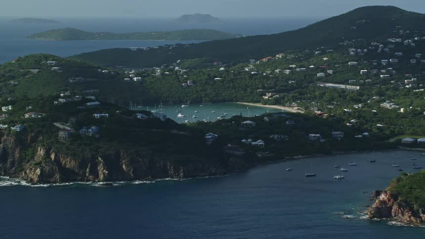 Aerial view of a coastal town on the slpoes of the mountains surrounded by the ocean