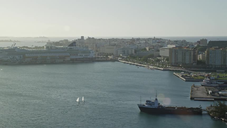 Aerial panorama of a cruise ship docked in the port next to hotels with a port next to it