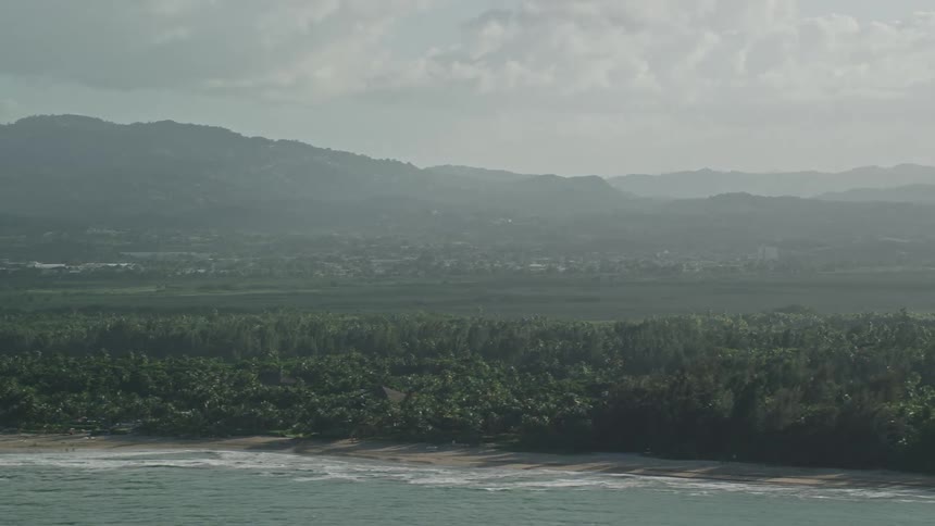 Aerial panorama of an island with tropical forest and a turquoise sea one morning