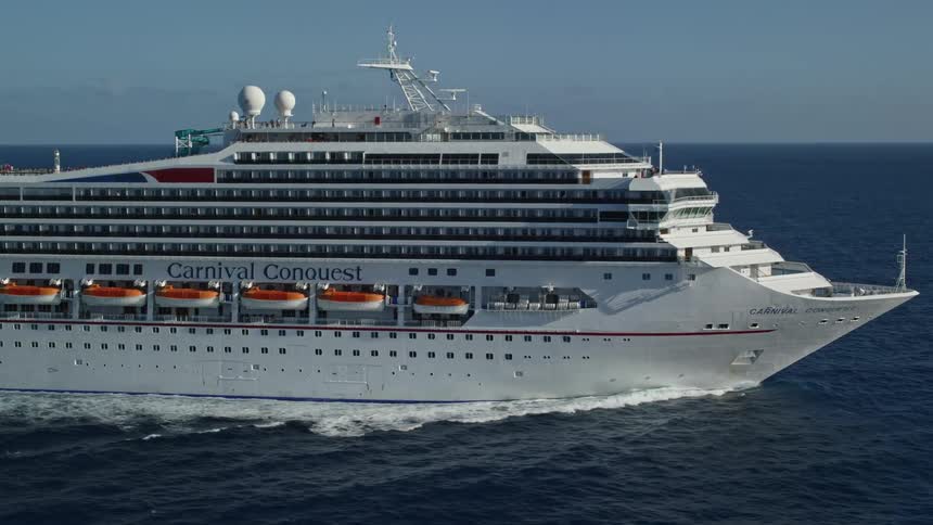 A huge white cruise ship sailing in a vast ocean with land far away
