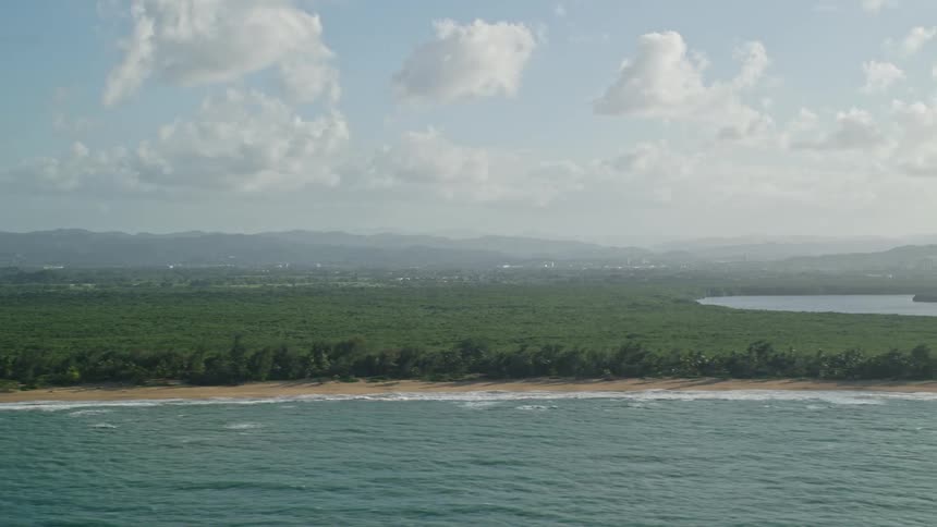 Aerial panorama overlooking the turquoise sea and vast vegetation on a cloudy day
