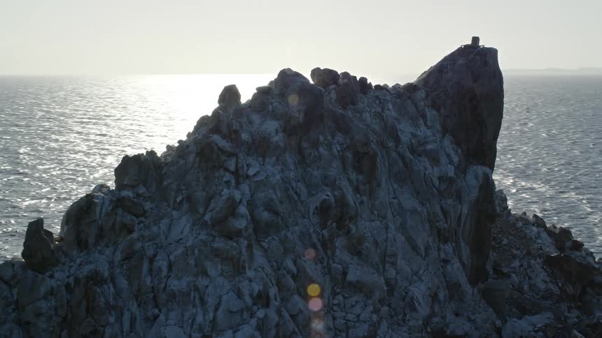 A tall rock formation in the middle of the sea