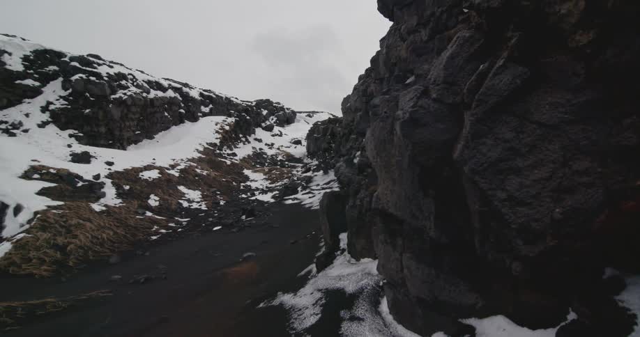 A snowy rocky hill on a cloudy day