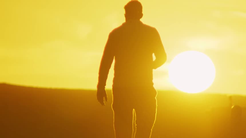 A man walking in slow motion outdoors on a sunny day