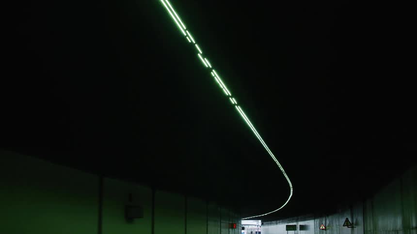 Lights run along the ceiling of a tunnel