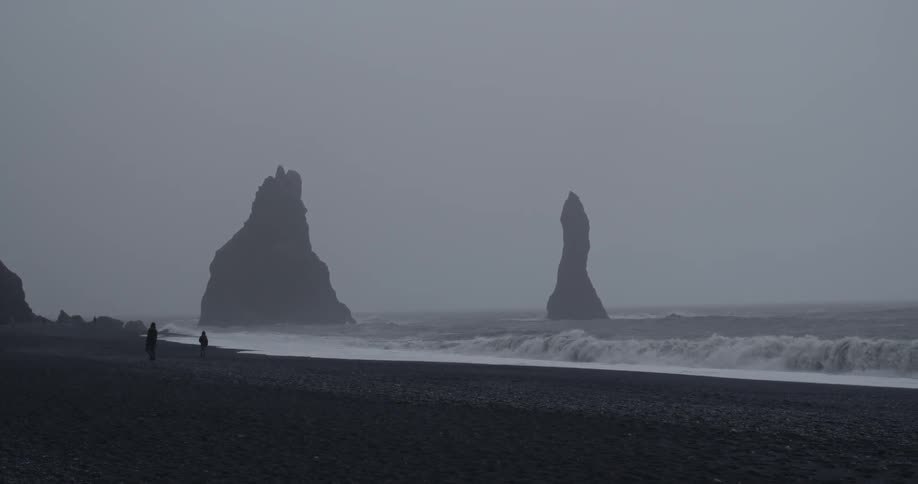 Two people on a misty beach at dusk