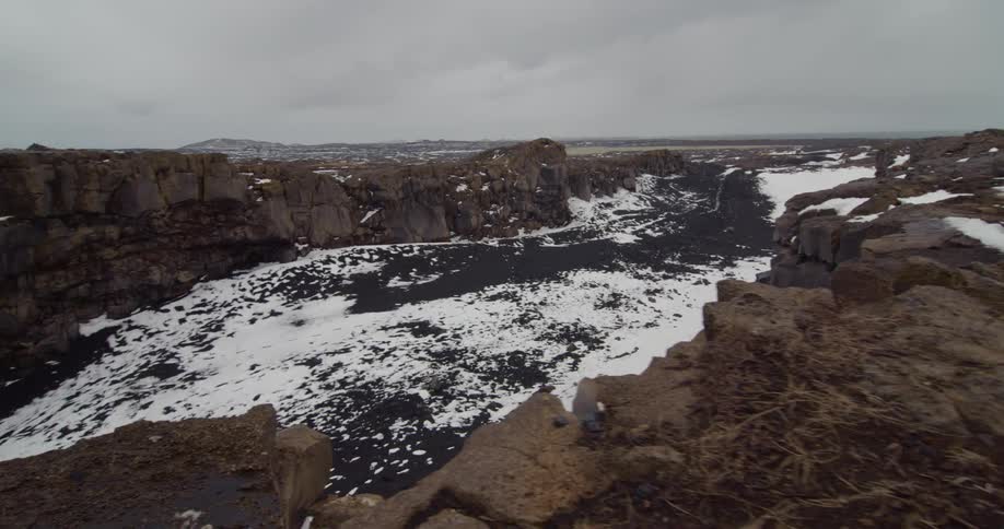 Snow partially covering the ground among large rock formations