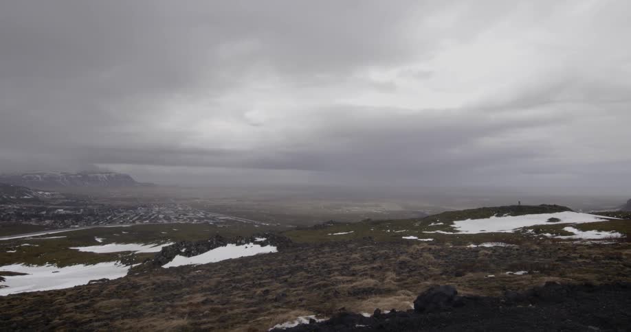 Snow and ice scatter across a foggy mountain landscape
