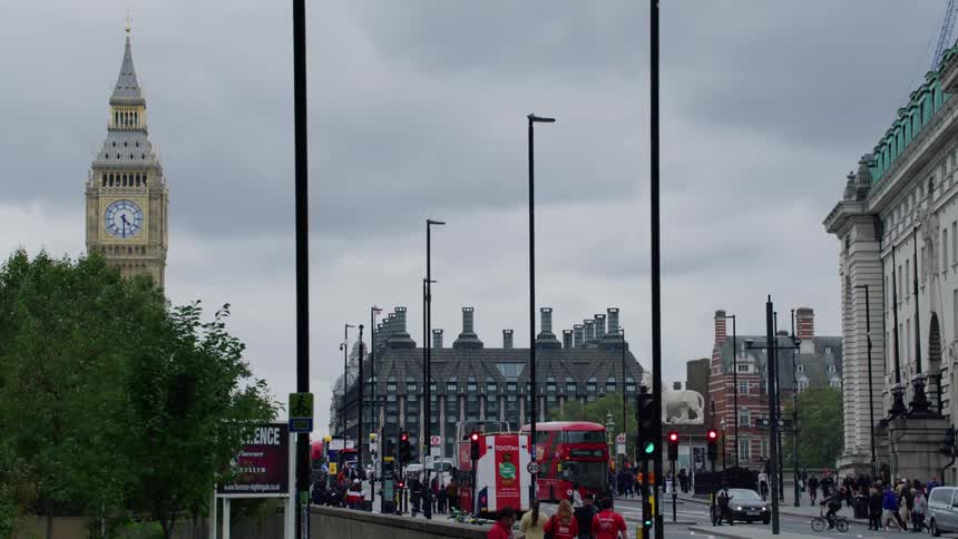 Vehicles and people move around a city street