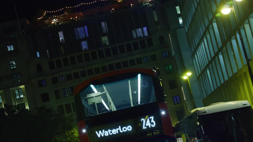 Public bus in motion amid a metropolis at night