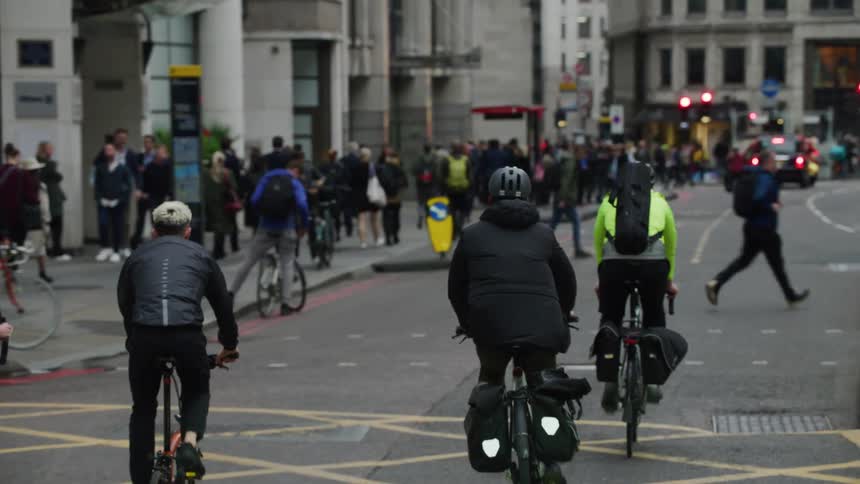 People on bicycles going down the road on a busy london street