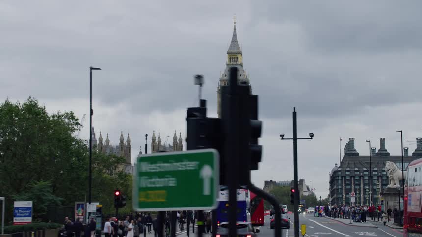 Big ben clock tower double decker buses and city street scene