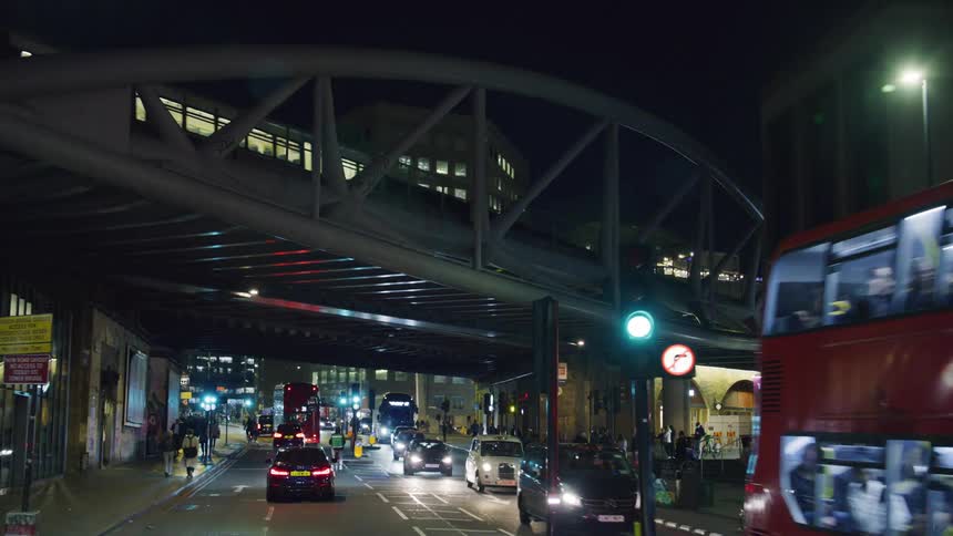 Busy public street with people and vehicles in a metropolis at night