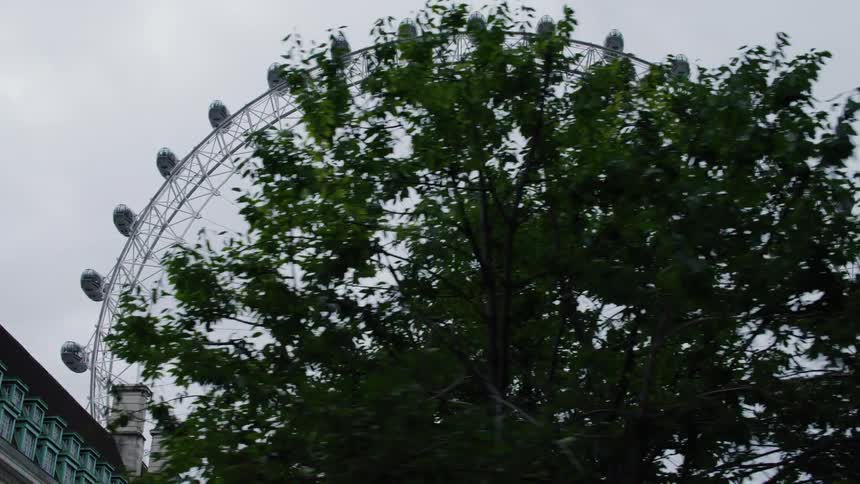 A large ferris wheel is by the building