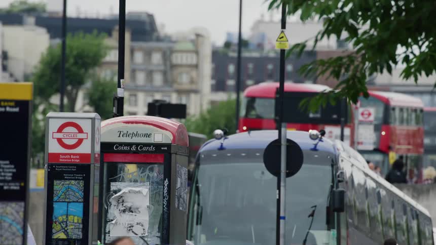 View of a public street with people riding on parked public buses