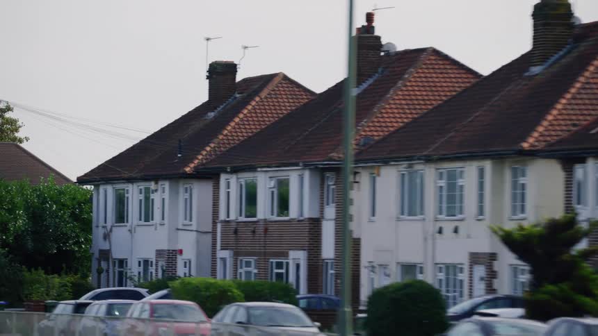 A suburban street a block of attached wellmaintained houses with cars parked in front of them