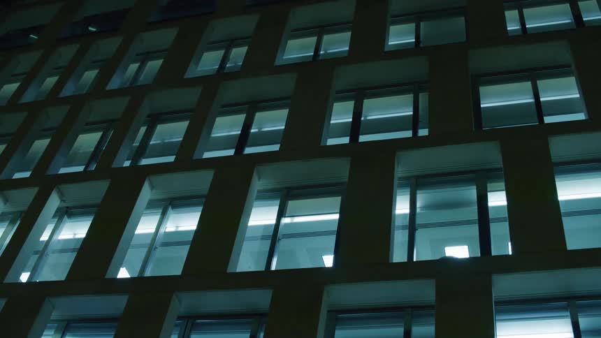 External architecture of a building with several windows in the middle of a metropolis at night