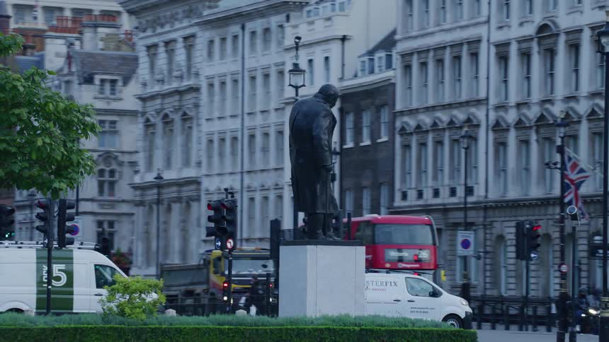 View of a small central square with a statue in the midst of a bustling metropolis