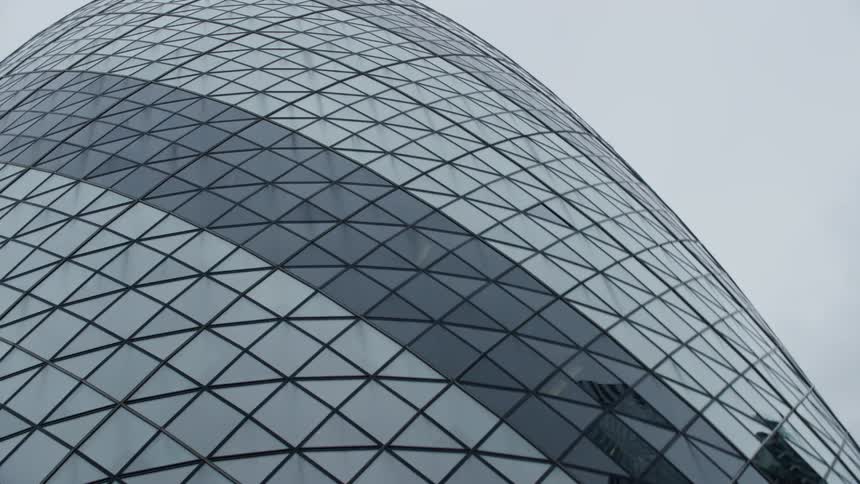 Modern and exterior architecture of a glass and ovalshaped mirrored building