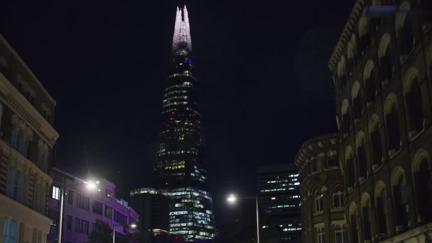 View of a towering building in the midst of a metropolis at night